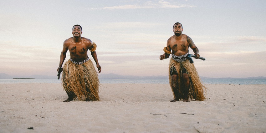 Image of two Men Wearing Skirts Standing on a Beach - Join the traditional dance