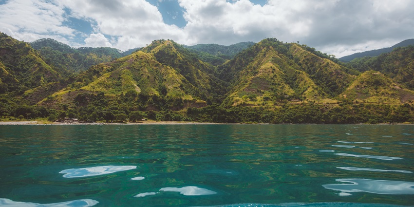 Scenic view of Lake Nyasa with gentle hills and calm waters beneath a blue sky