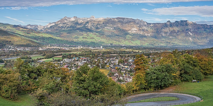 Glimpse of vast city of Liechtenstein with lush green surroundings and hills far away.