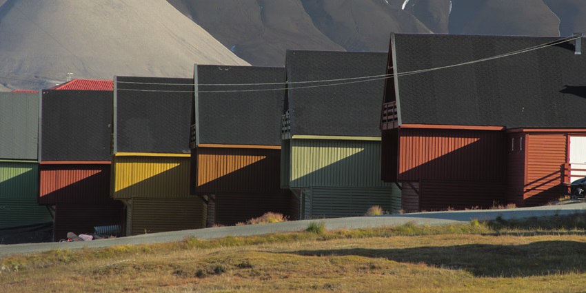 Longyearbyen townscape with colourful buildings nestled in snowy Arctic mountain surroundings, one of the best places to visit on the Svalbard islands.