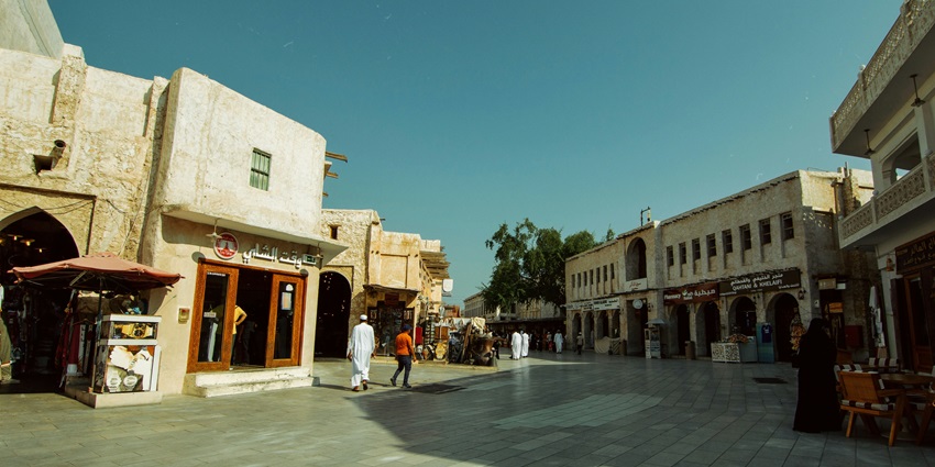 Image of a complex with shops and people walking around during day time view