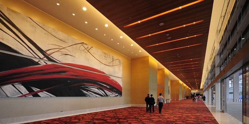 Spacious, modern interior of Sands Expo & Convention Centre set up for an international exhibition with booths and digital displays.