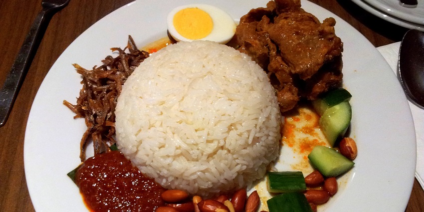 Nasi lemak served with lamb curry, boiled egg, roasted peanuts, and fragrant rice