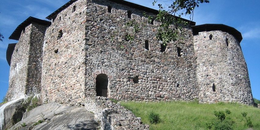 Medieval ruins of Raseborg Castle in Finland, perched on rocky ground amid forest