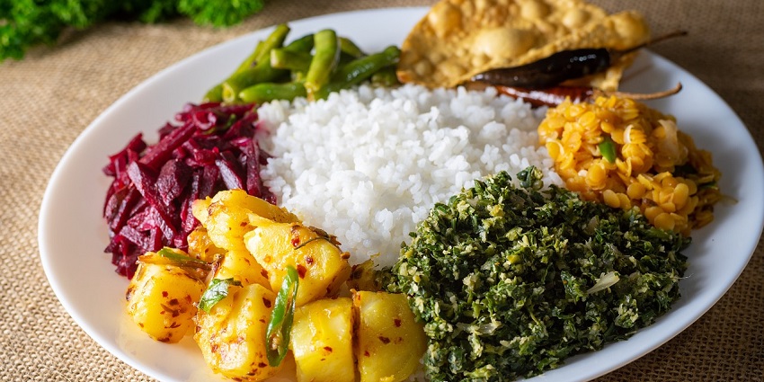 Image of a traditional plate of Rice and Curry, a staple food in Sri Lanka, with rice and curries.