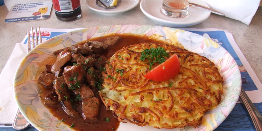 An image showing Leberli mit Rösti, a top food in Switzerland, served with sautéed liver.