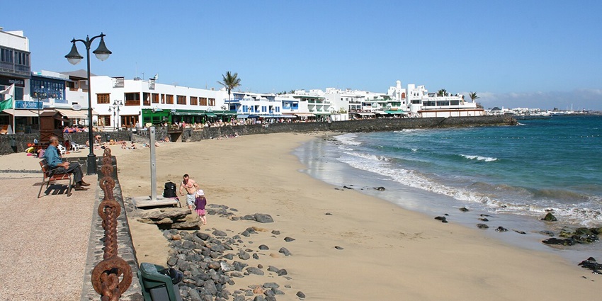 Golden sand beach with calm turquoise waters and sunbathers relaxing on this beach, one of the best things to do in Playa Blanca.