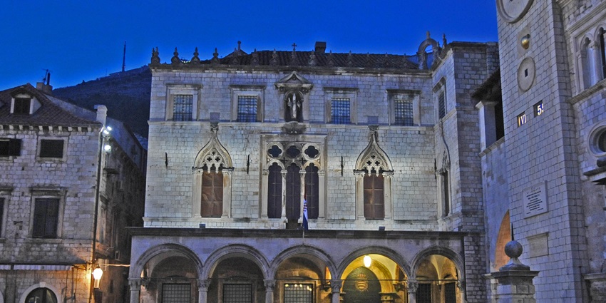 Illuminated Gothic-Renaissance Sponza Palace glowing at night in Old Town Dubrovnik.