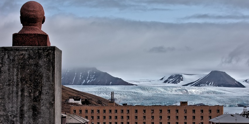 A majestic view of distant glaciers and peaks from the iconic buildings of Pyramiden