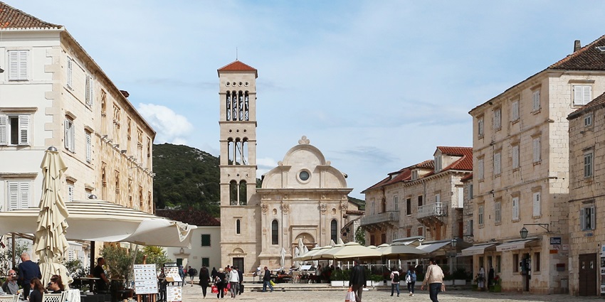 A front view of St. Stephen’s Cathedral in Hvar, showcasing its detailed facade, bell tower, and historical architectural charm in the town square.