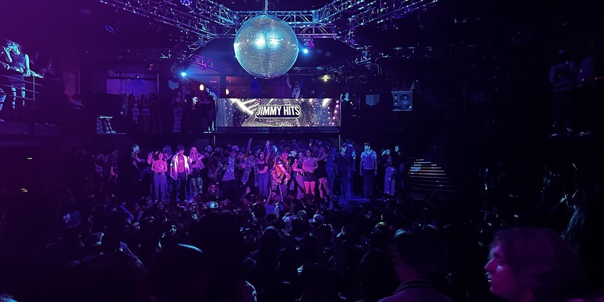 A picture of an illuminated nightclub in Muscat with people enjoying and dancing