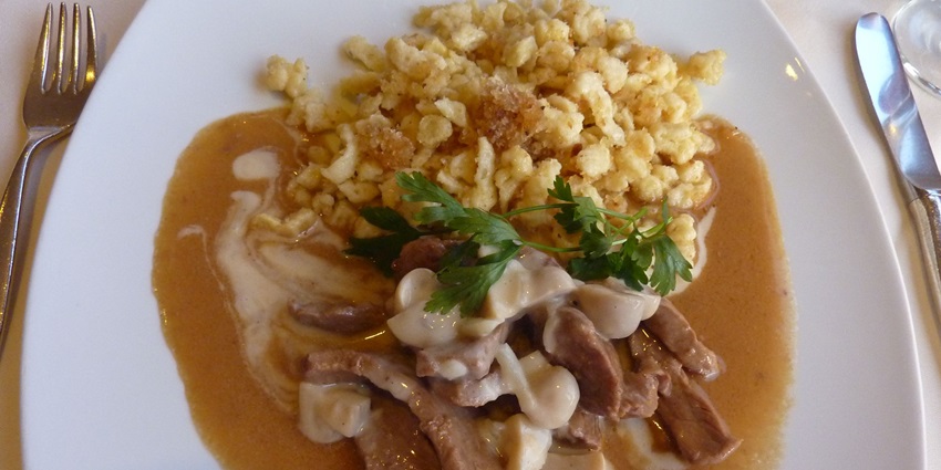 An image showing Zürcher Geschnetzeltes, a Swiss dish of sliced veal in a creamy white sauce.