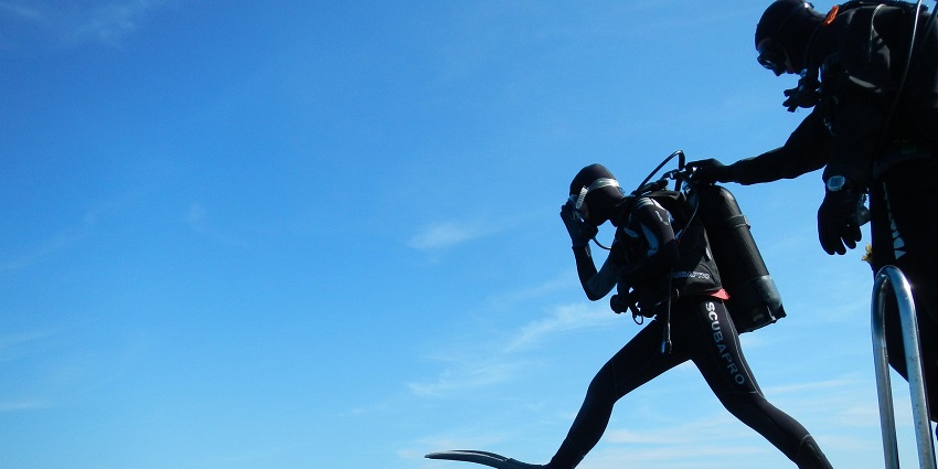 Image of a person ready for scuba diving and witness corals in the water while scuba diving at Koh Ha