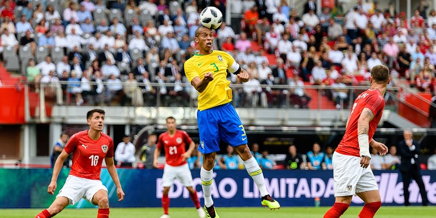 Ongoing match between Brazil and Austria with a player giving a header and others looking at