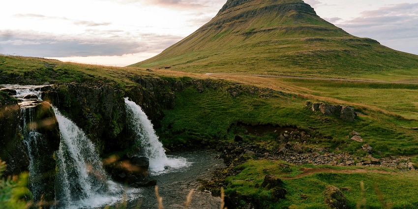 Panoramic view of waterfall, a majestic semicircular cascade surrounded by lush cliffs.