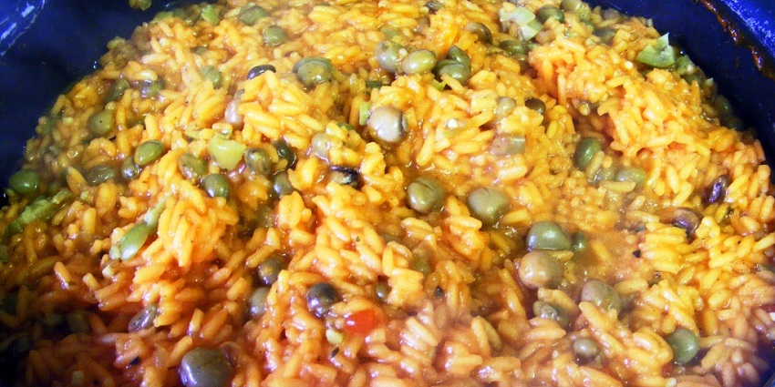 An Image of a serving of Arroz con Guandú with coconut rice and pigeon peas.