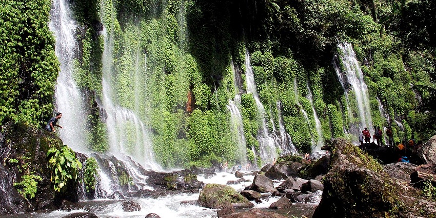 Visitors marvel at the breathtaking Asik-Asik Falls, surrounded by lush greenery