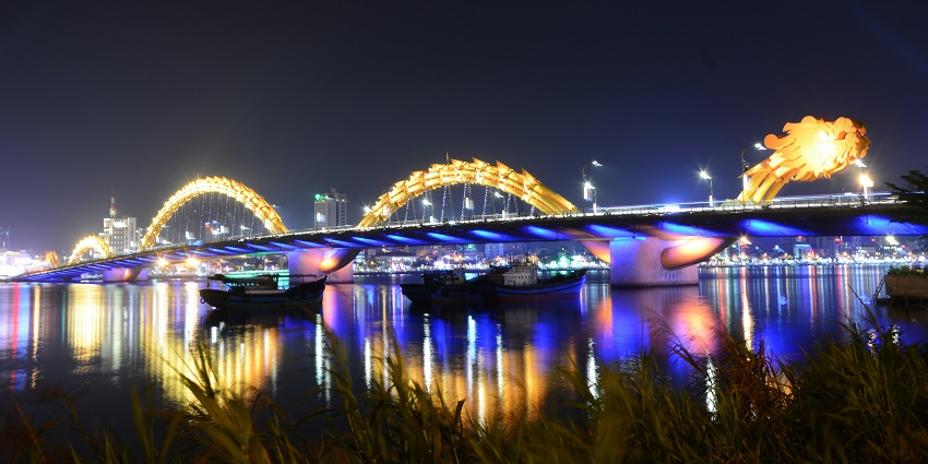 The famous Bridge spewing fire during a weekend night show, with a crowd gathered below.