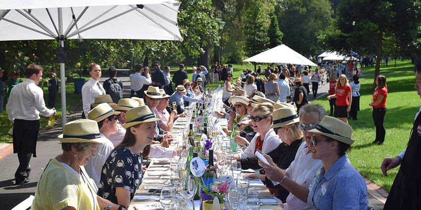 People enjoying food and drinks outdoors during the Melbourne Food and Wine Festival in Australia.