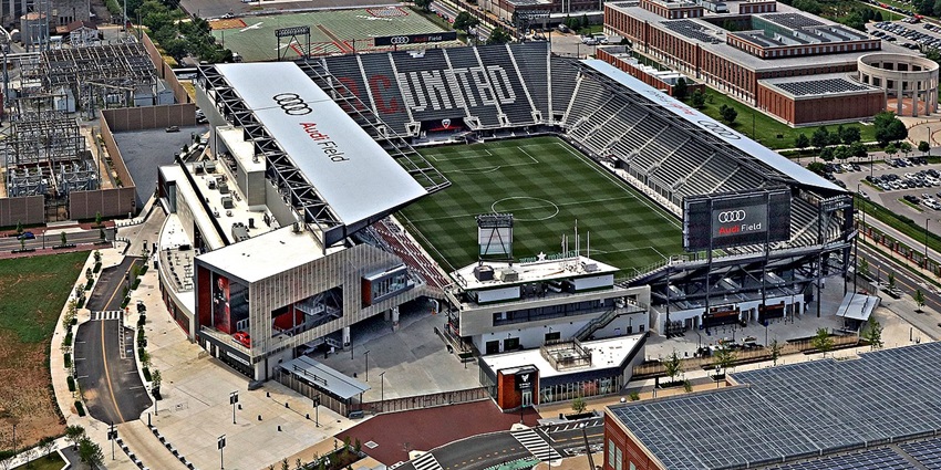 Audi field with modern architecture, Audi signages on the roof and distant vehicles parked
