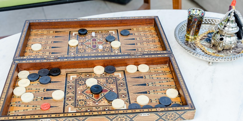 Artistic wooden backgammon sets featuring mother-of-pearl inlays at a traditional market.