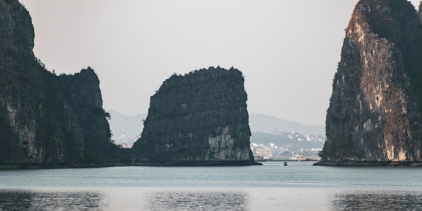 A tranquil scene of Ha Long Bay's iconic limestone islands, with calm emerald waters