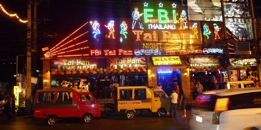 Neon-lit Bangla Road in Phuket during nighttime with bars and a lively atmosphere.