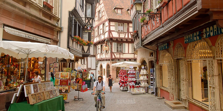 Vibrant tourist area in Colmar’s old town, with traditional half-timbered houses and streets.