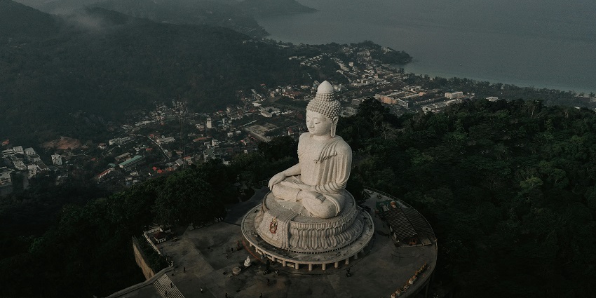 Aerial view of Big Buddha in Phuket surrounded by lush greenery amidst green hills
