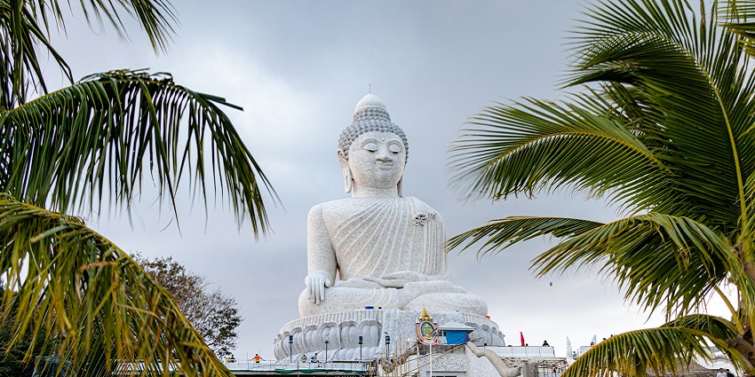 A glimpse of the majestic statue of Big Buddha surrounded by lush green vegetation.