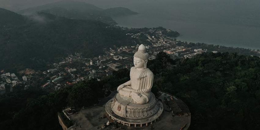 A glimpse of the majestic Big Buddha statue nestled amidst the lush green vegetation.