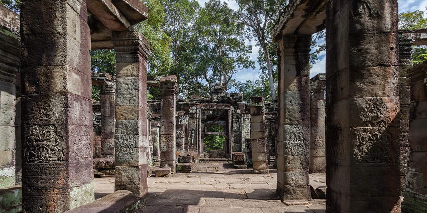 Banteay Kdei ruins in Siem Reap with crumbling galleries and seated Buddha statue