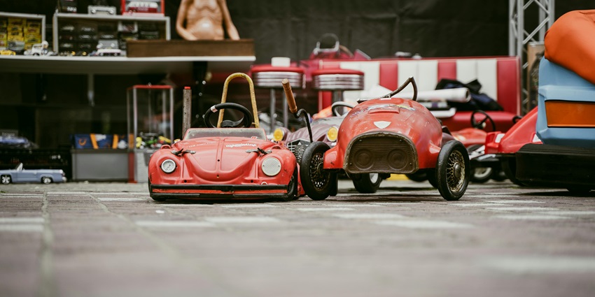 An overhead close-up of a collection of vintage-style red toy cars arranged in neat rows in Airzone, one of the best things to do in Singapore with family.