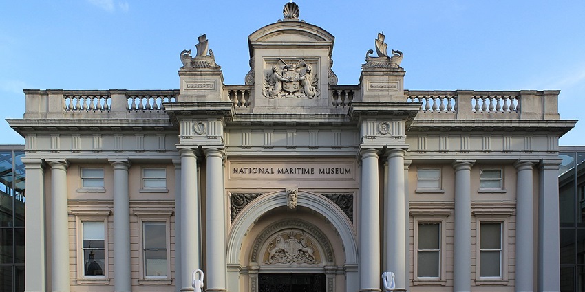 Exterior view of Galata Maritime Museum with glass panels and anchored boat, a maritime thing to do in Genoa.