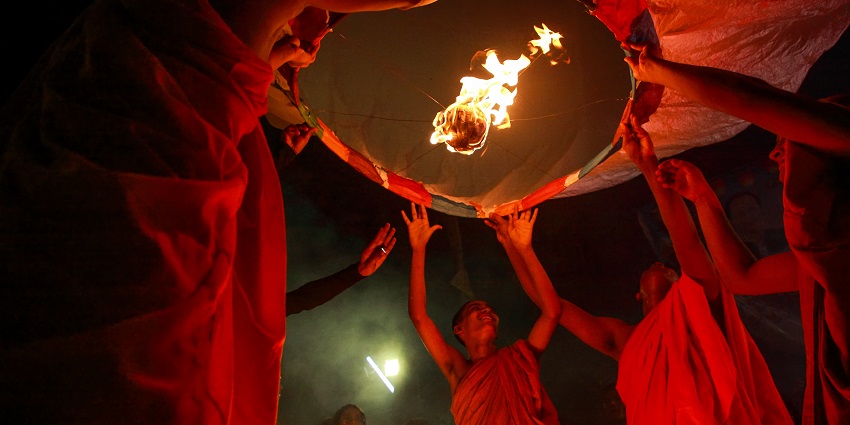 Devotees celebrating Buddha Purnima with candles and lanterns in a night procession