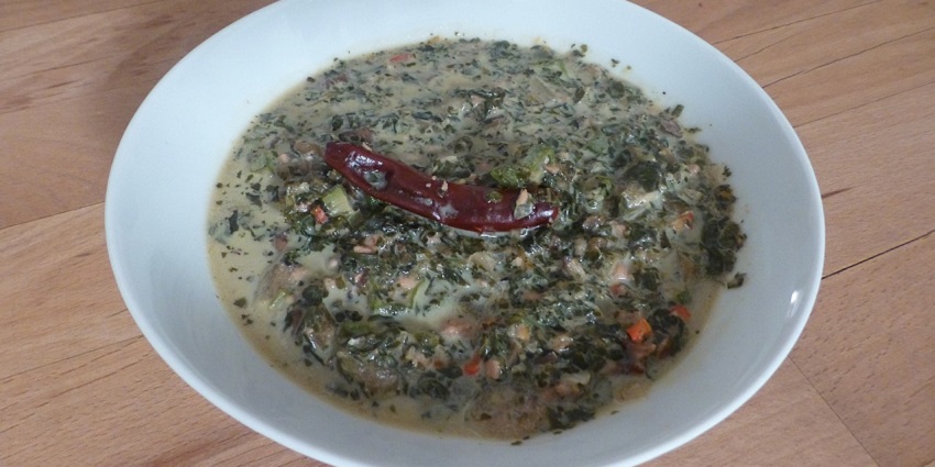 An image of a plate of sautéed Callaloo with onions, tomatoes, and Scotch bonnet.