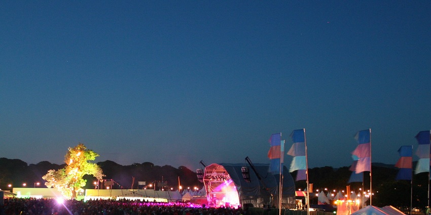 A night view of the Camp Bestival with an open theatre lit in different coloured lights