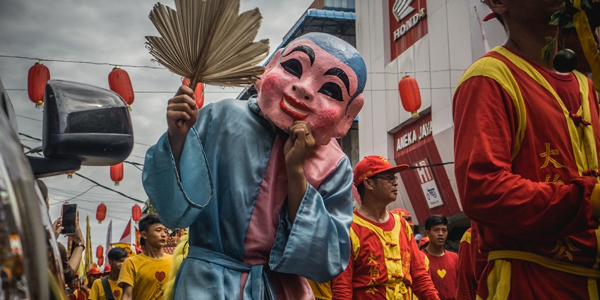 A person wearing a traditional mask during Cap Go Meh, a traditional festival in Indonesia.