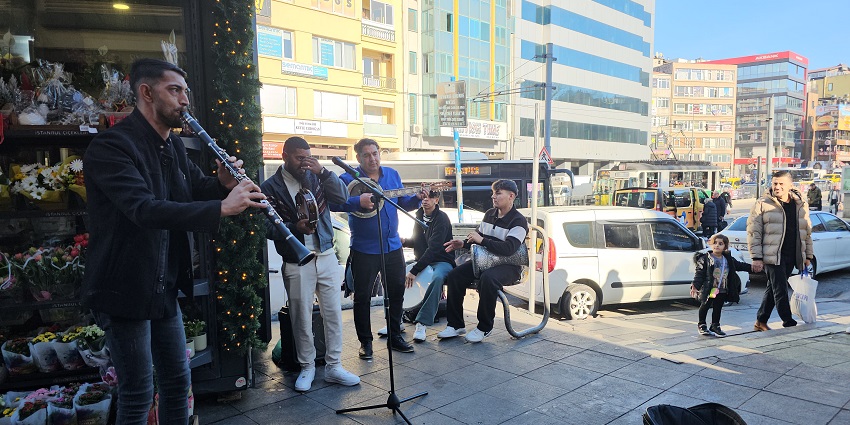 Street artists in a group play live music with various instruments in the streets