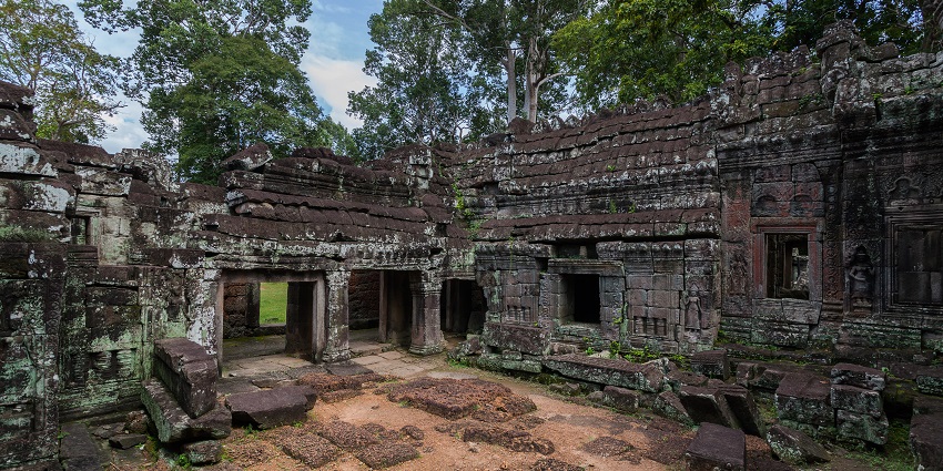 Golden sunlight falling on weathered stone carvings of a historic Angkor temple
