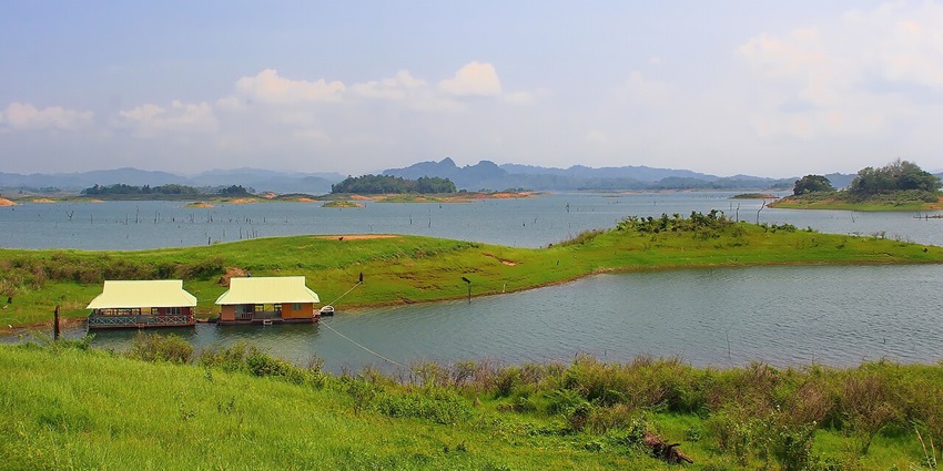 Panoramic view from Khao Leam Yai Viewpoint showcasing lush green hills and the sea.
