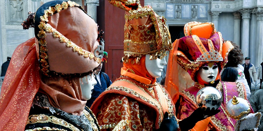 Colourful masked figures in elaborate costumes during the Venice Carnival celebrations