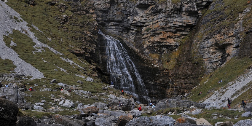 Cascada Cola de Caballo waterfall with few visitors in a lush mountainous landscape.