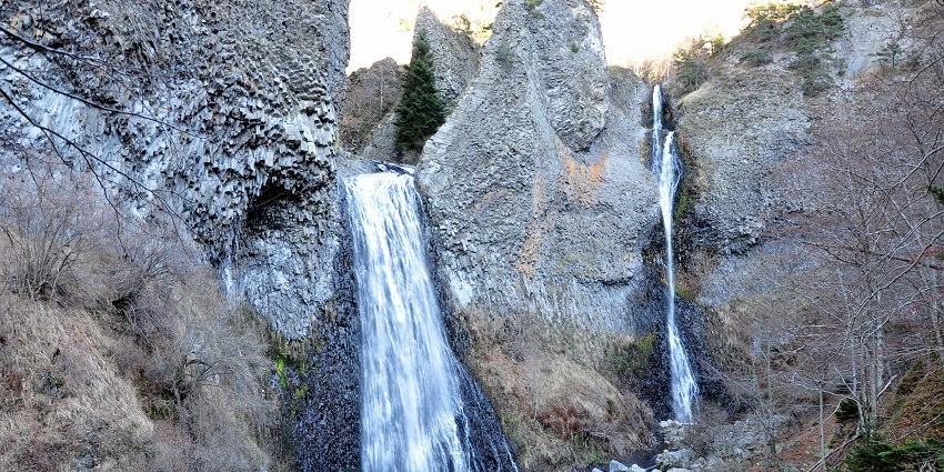 Cascade du Ray Pic flows into a small pool next to a small waterfall from rocky cliffs