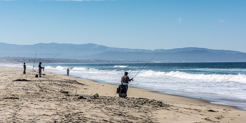 An image of people surfing, fishing, which is among the tourist best things to do in Avon, Nc.