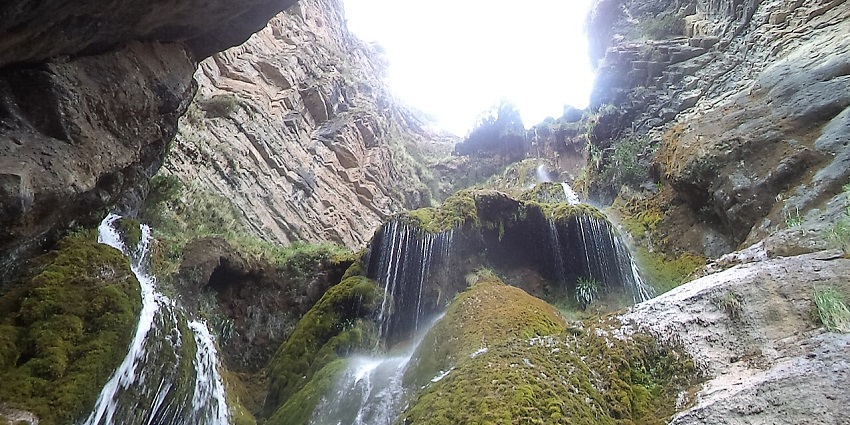 Catarata de Pucayaquillo waterfalls with water flowing on the green rocky surface