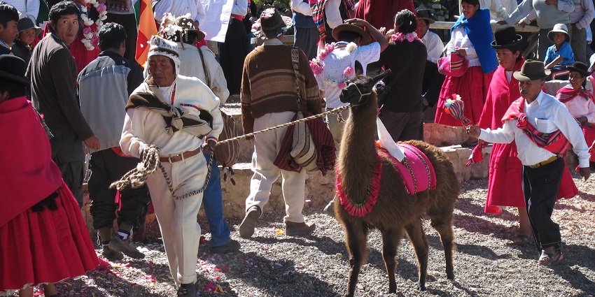 Aymara ceremony Ch’alla with flower petals, alcohol offerings, and blessings for Pachamama during festivals.
