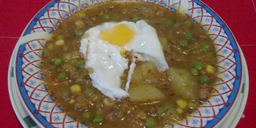 An image showing Charquicán, a mashed stew with meat, potato, and pumpkin.