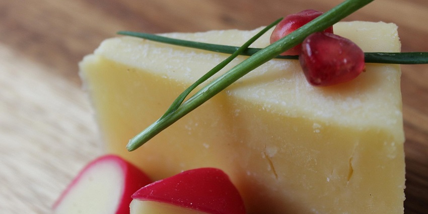 An image showing a view of traditional Cheddar cheese, a famous thing to buy in UK.