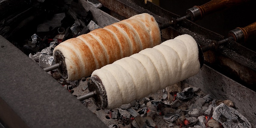 An image showing Chimney Cake, a rolled sweet pastry baked over an open flame.